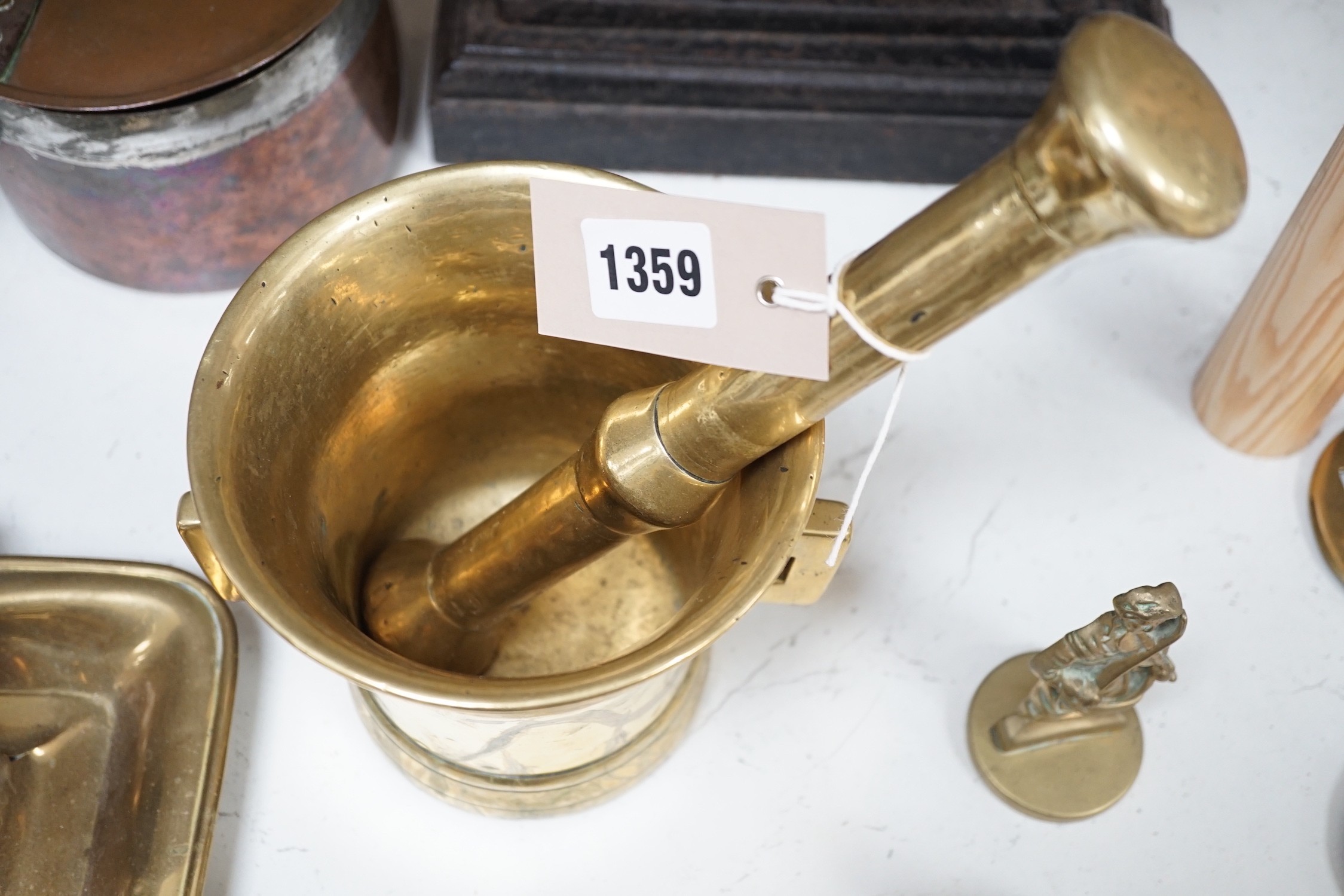 A large brass pestle and mortar and other metalware